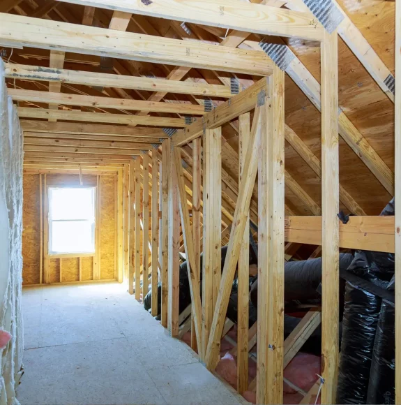 Renovated attic with wooden supports, a bright window, and a long hallway designed by AC Reformas